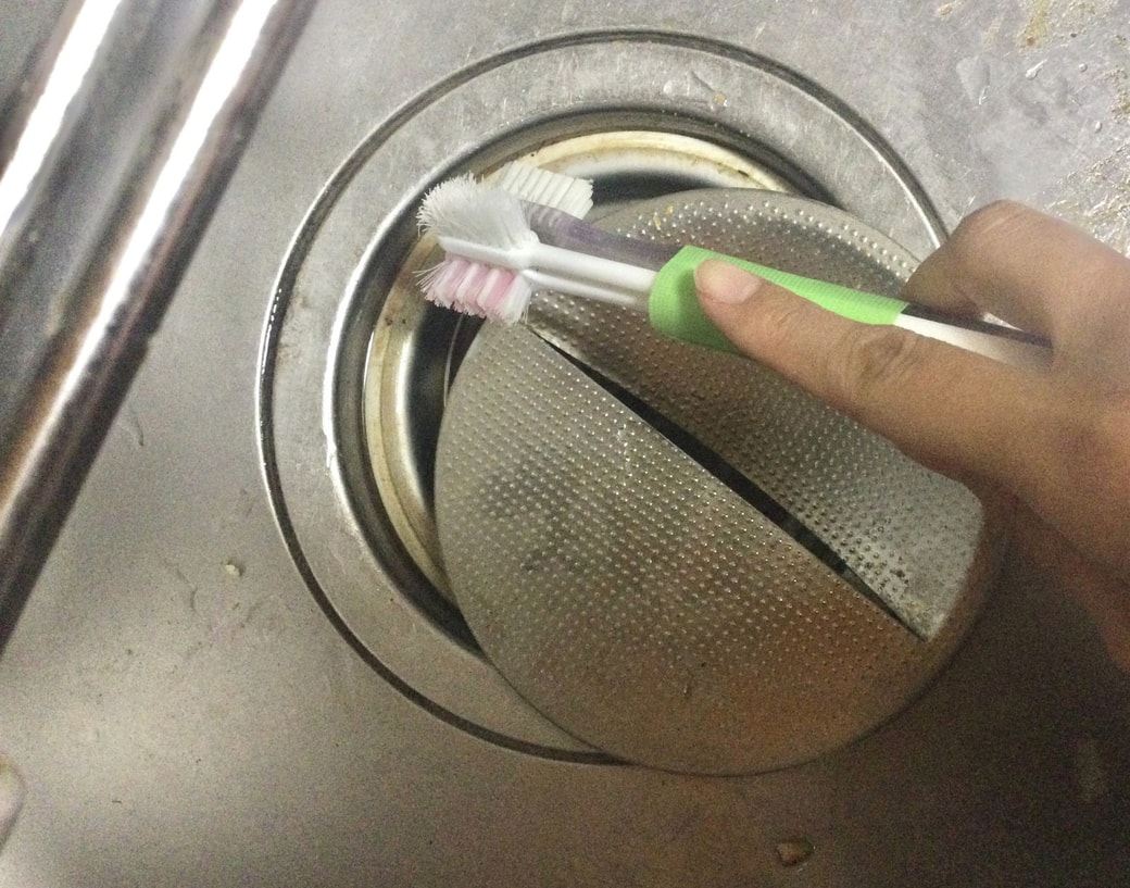 束ねた歯ブラシで掃除する様子