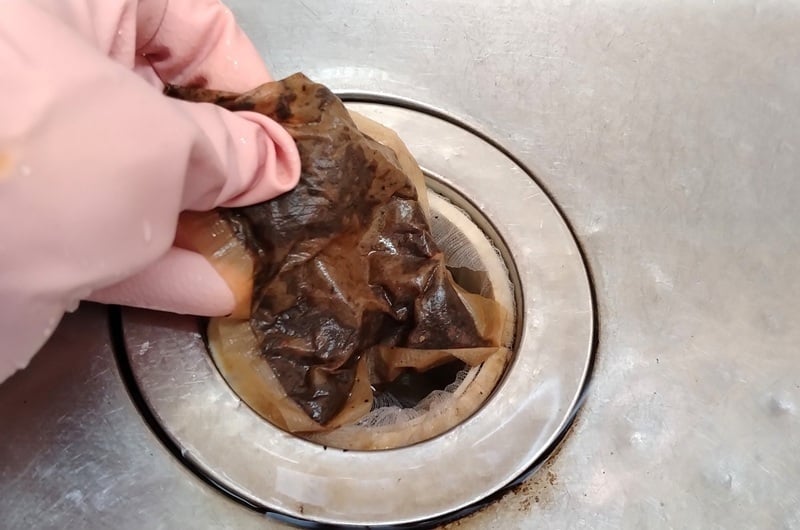 麦茶パックを排水口のゴミ受けに入れる様子