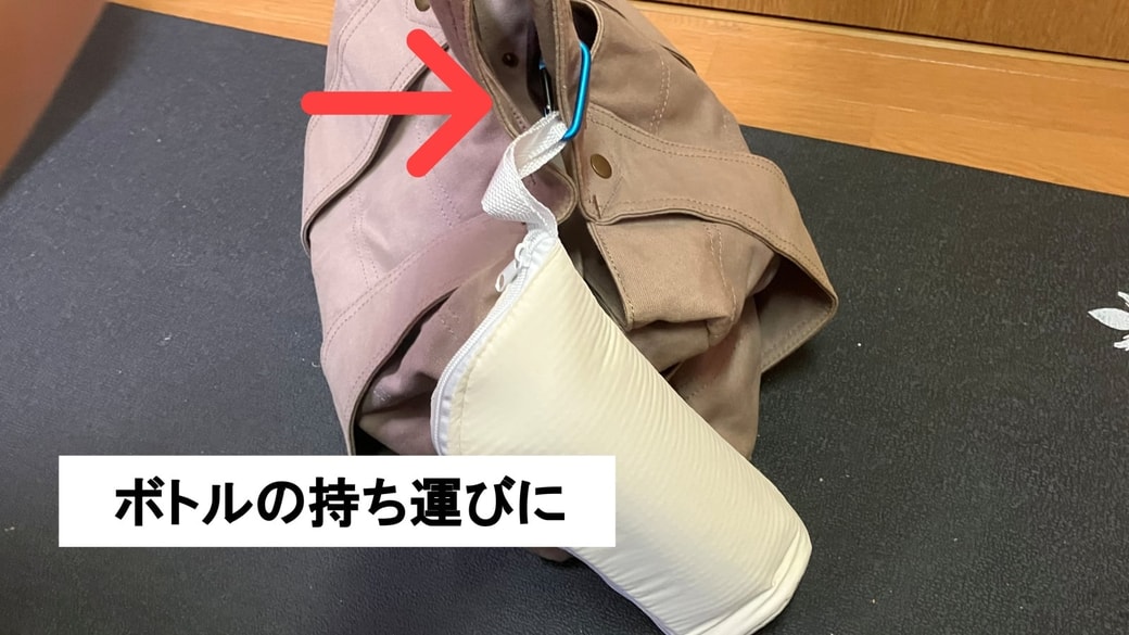 ボトルホルダーをカラビナを使用して鞄に取り付けている様子