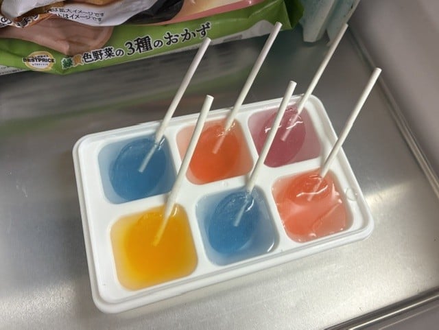 製氷皿に棒つきキャンディを入れるところ