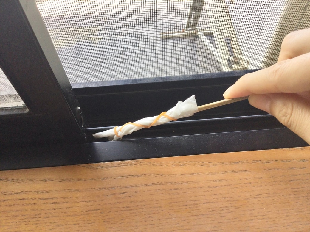 お掃除棒でサッシを掃除する