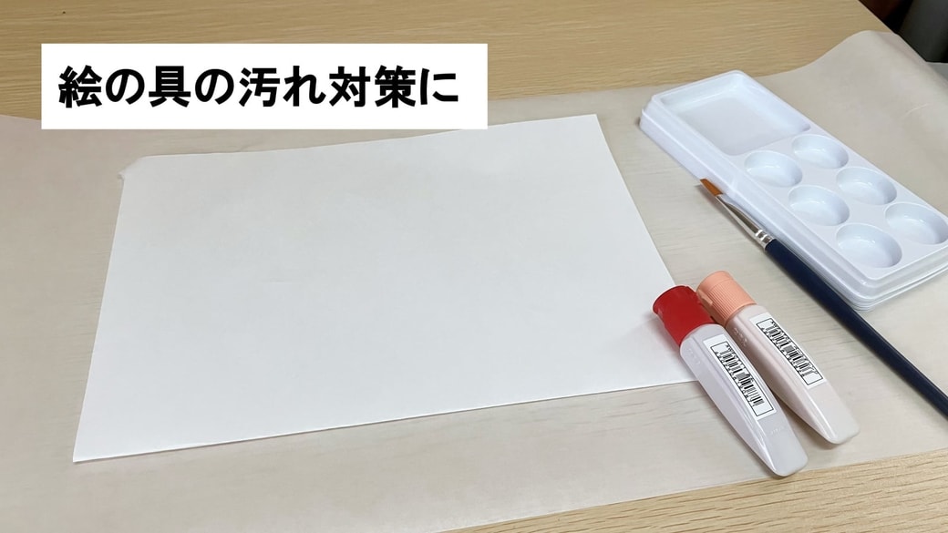 絵の具の汚れ対策にクッキングシートを活用している様子