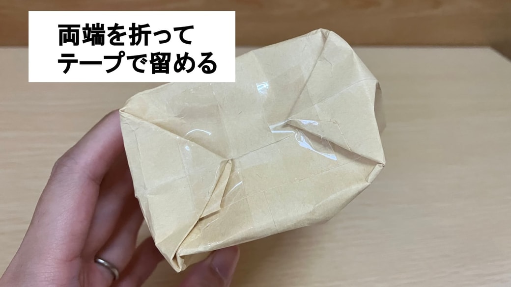 封筒の底をテープで留めている様子