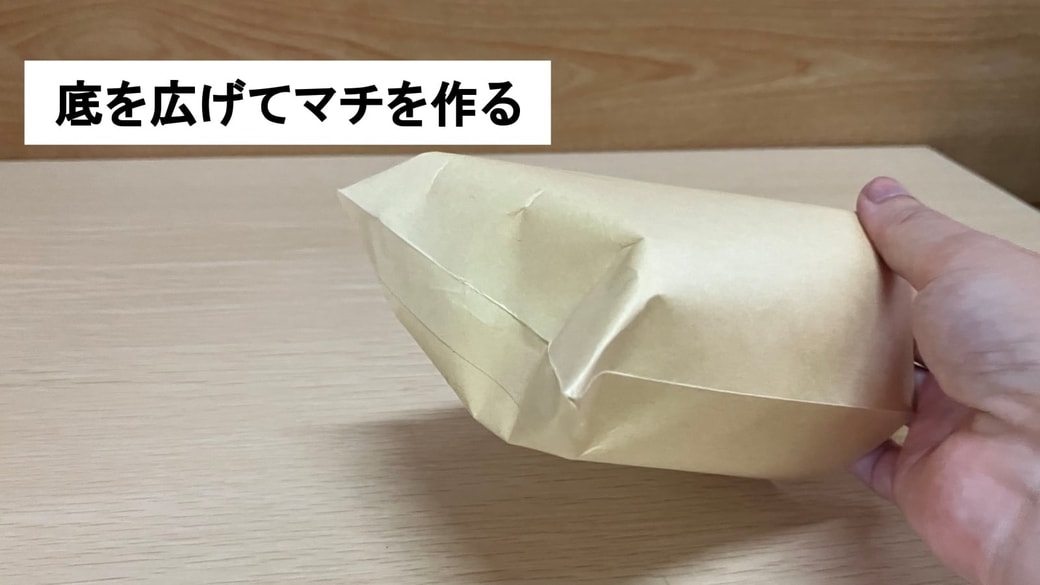 封筒の底を広げてマチを作っている様子