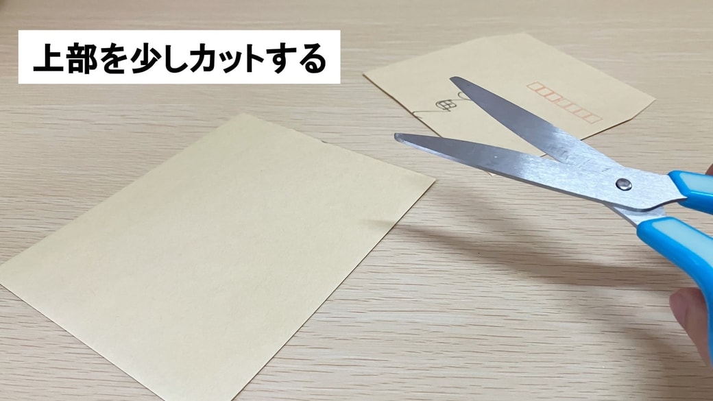 封筒の上部をカットしている様子