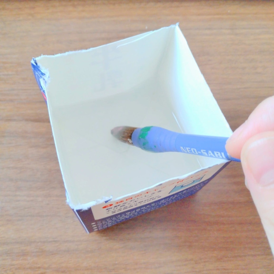 牛乳パックで絵の具の筆を洗う人