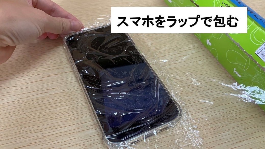 スマホをラップで包んでいる様子
