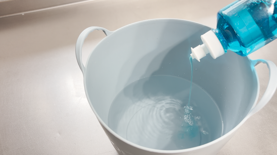 バケツの水に洗剤を入れる