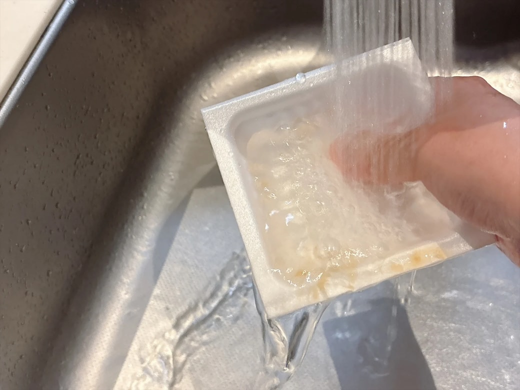 こすりながら流水で洗う