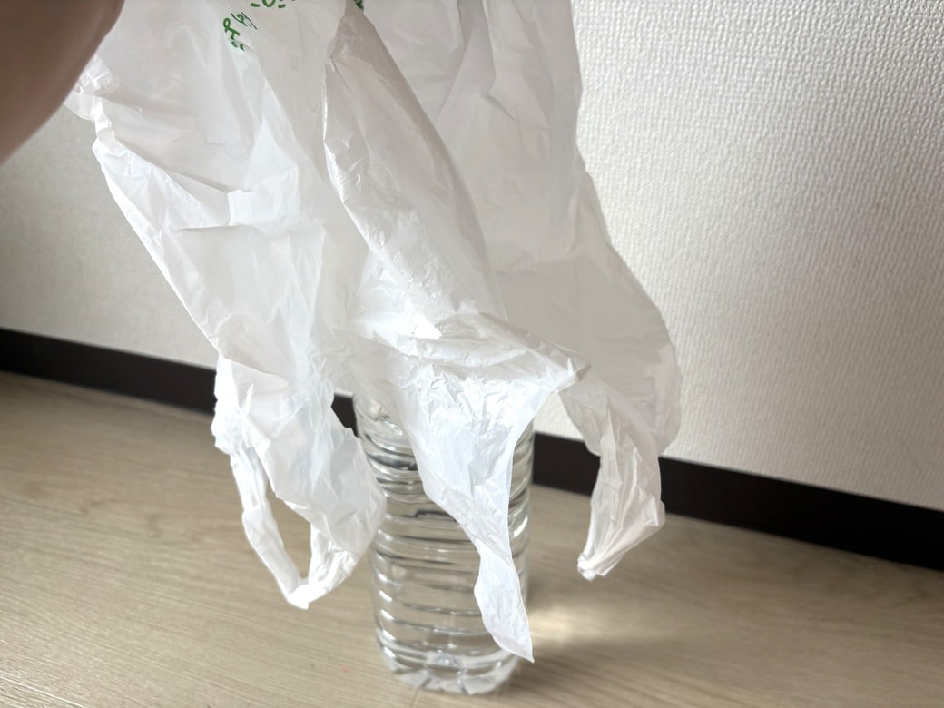 ペットボトルにレジ袋をかぶせる様子