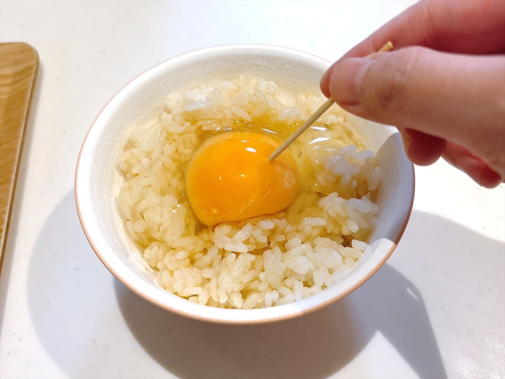手順2.ごはんの真ん中に卵を割り入れ、つまようじで穴をあける