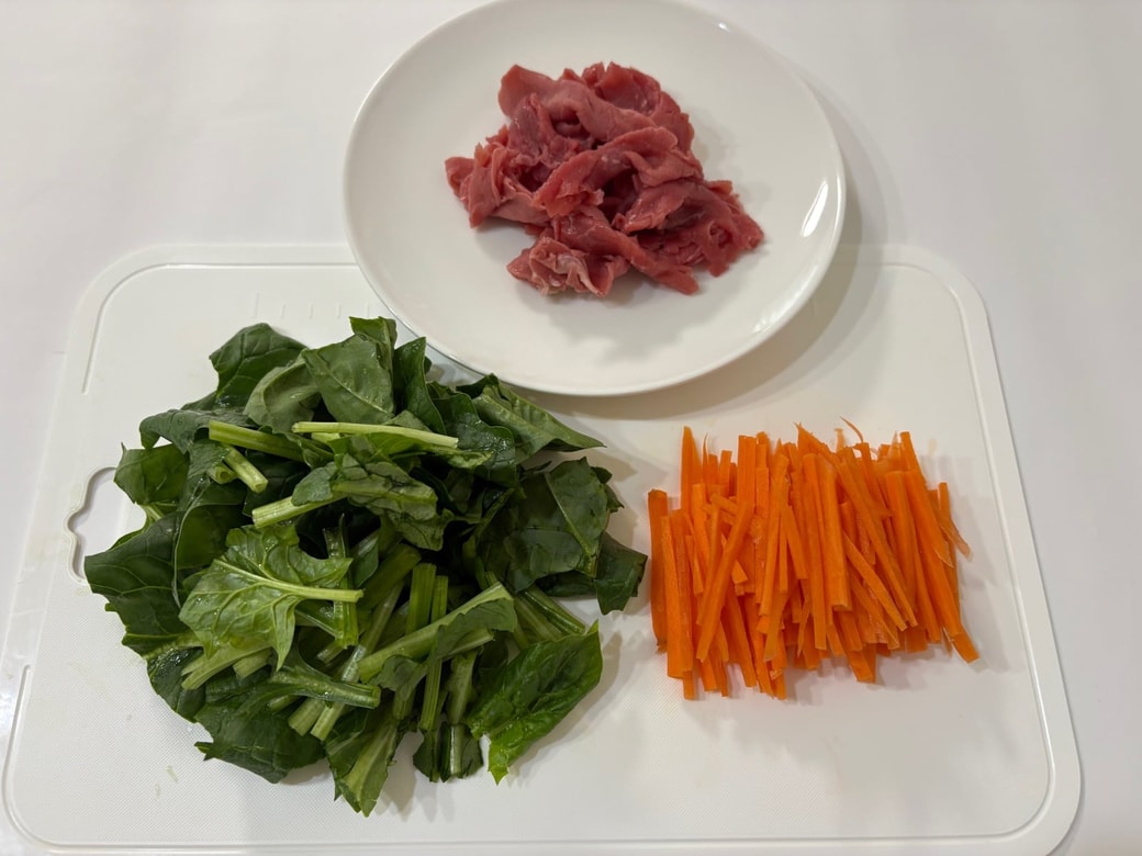 牛肉、ほうれん草、にんじんを切る