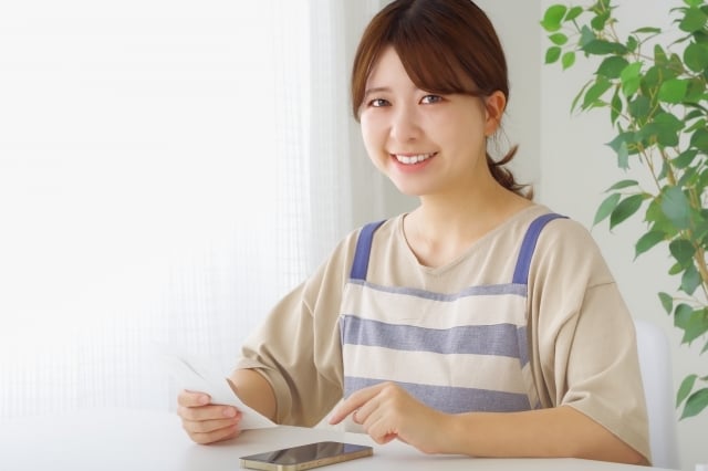 スマートフォンで支出の管理をする女性