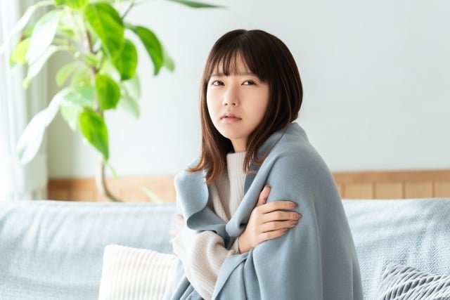 寒い部屋で我慢する女性