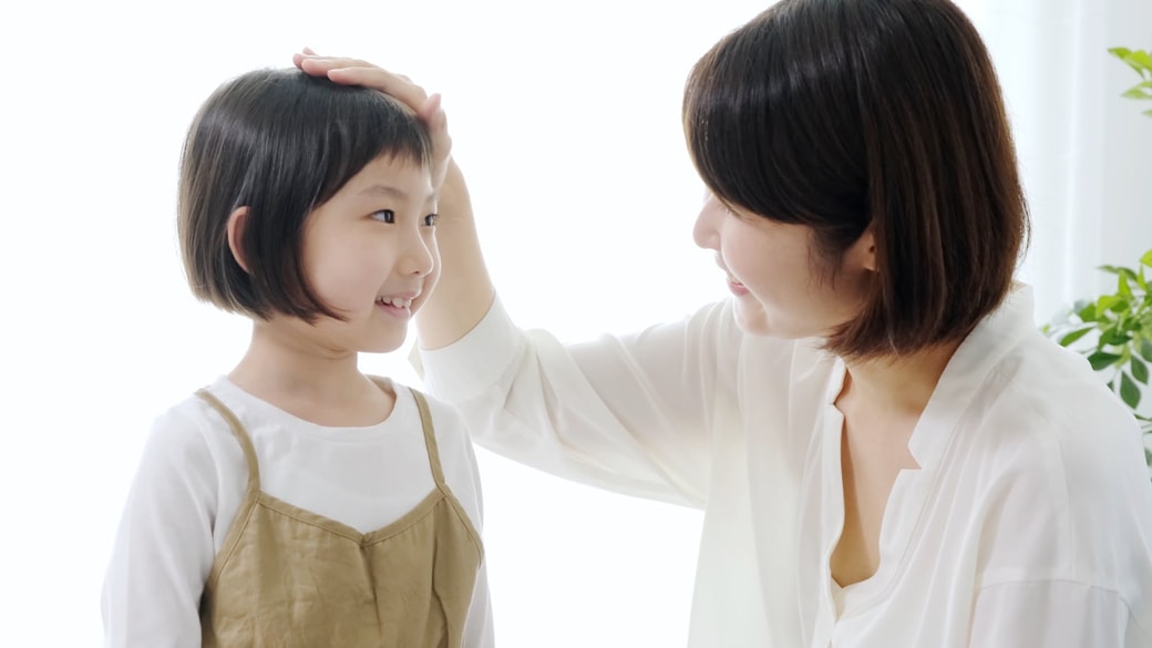 頭を撫でられる子ども