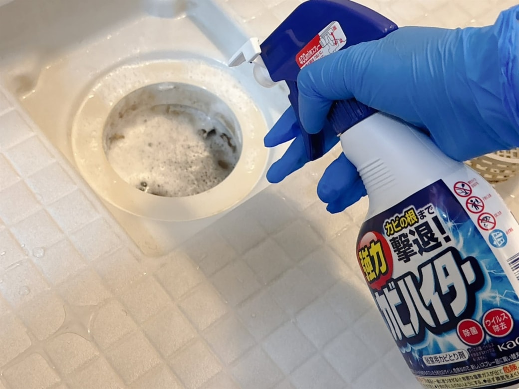 手順1.炊事用手袋をはめて浴室床側の排水口に、強力カビハイターをスプレーする