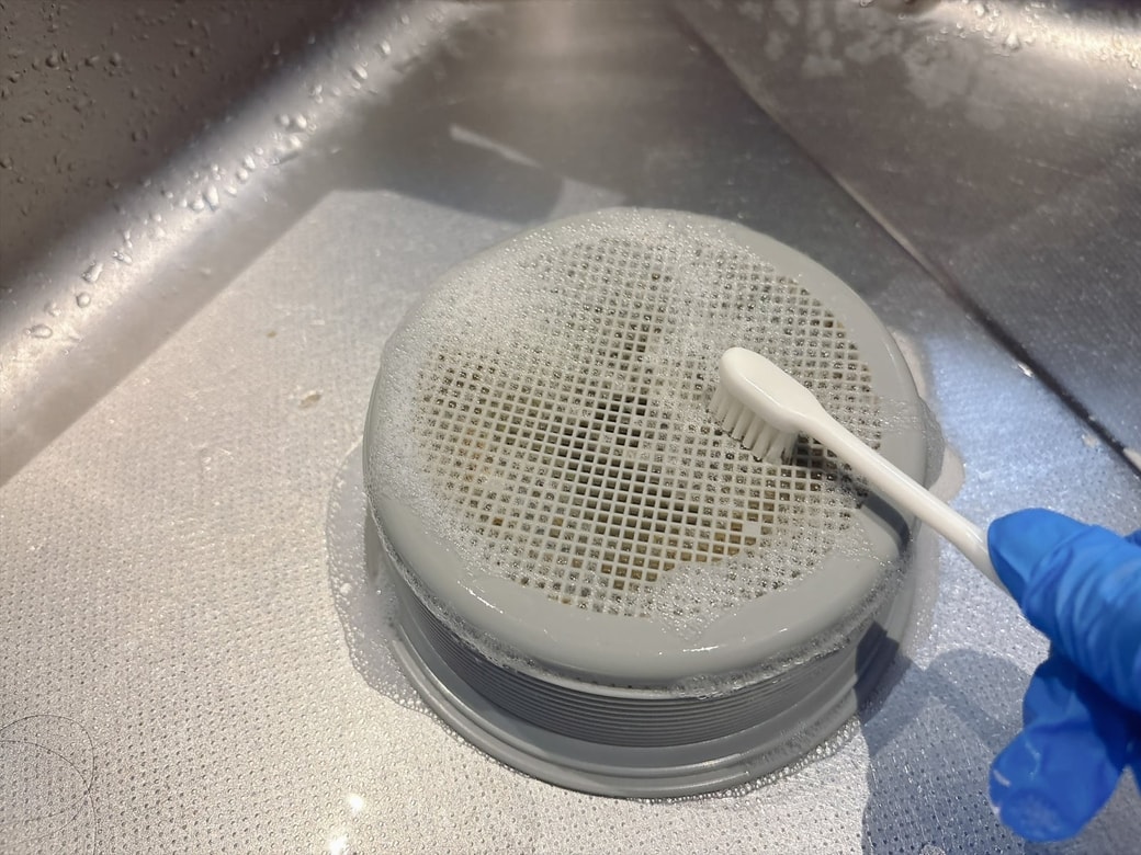 手順2.歯ブラシで汚れをこすり落とし、水で洗う