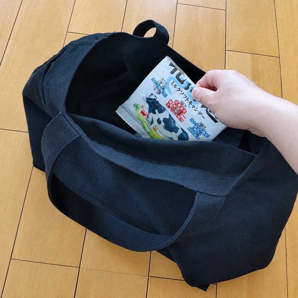 個包装の飴をバッグに入れる人