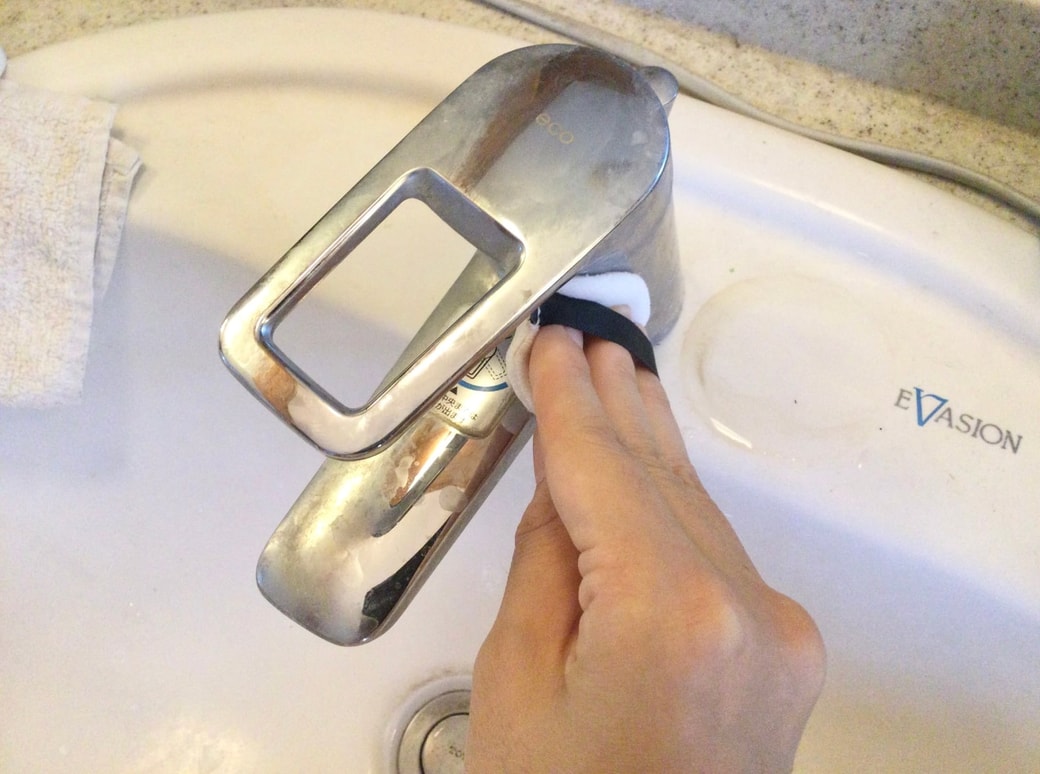 パフで蛇口の水垢掃除をする