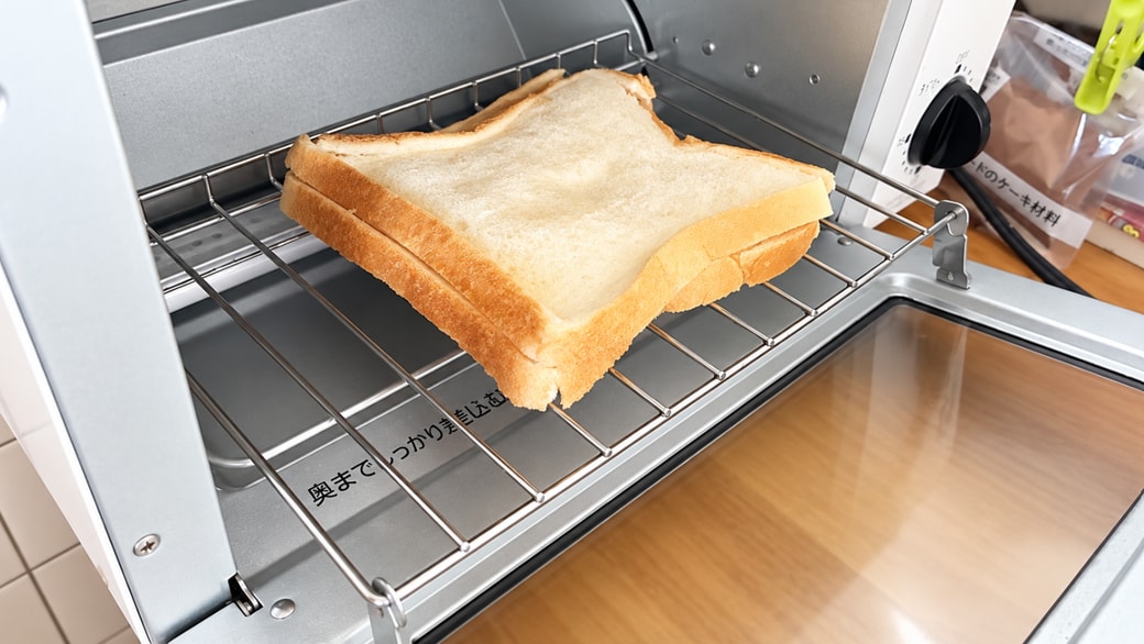 オーブントースターに食パンを入れている様子
