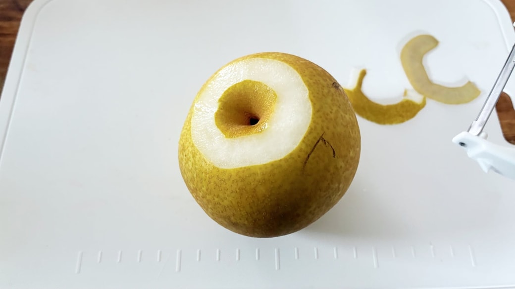 ピーラーを使って梨の皮をむいている様子
