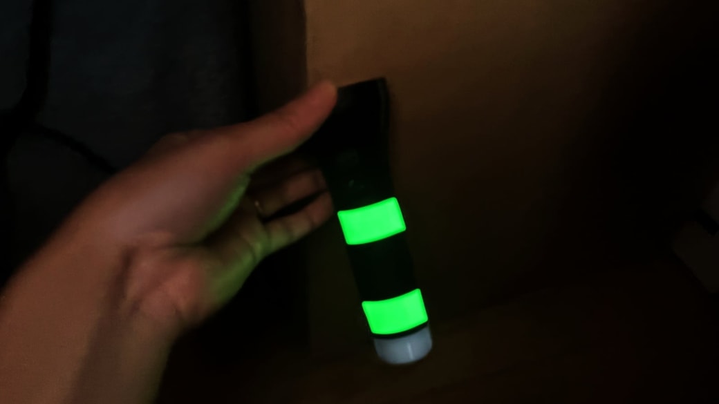 懐中電灯に貼りつけた蓄光テープが光っている様子