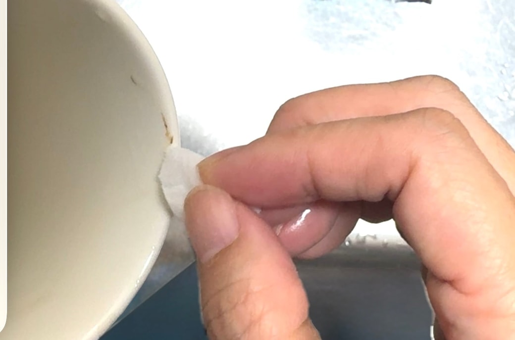 メラミンスポンジでカップについたシミをこすっている様子
