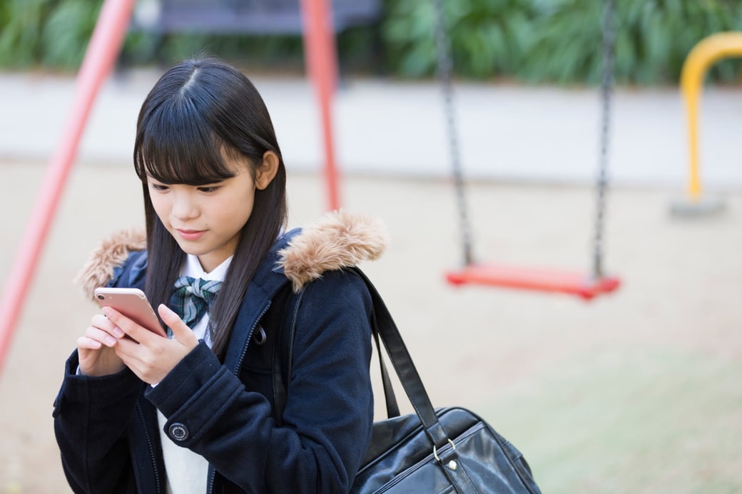 スマホを見る学生