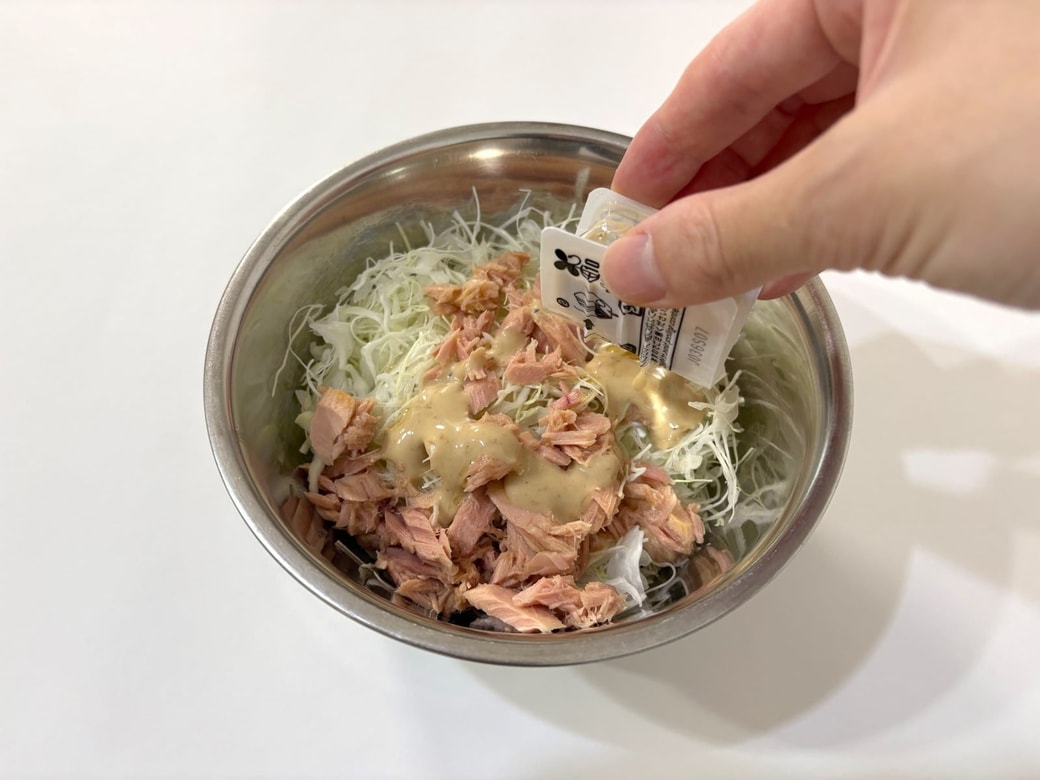 千切りキャベツとツナに素を絡める