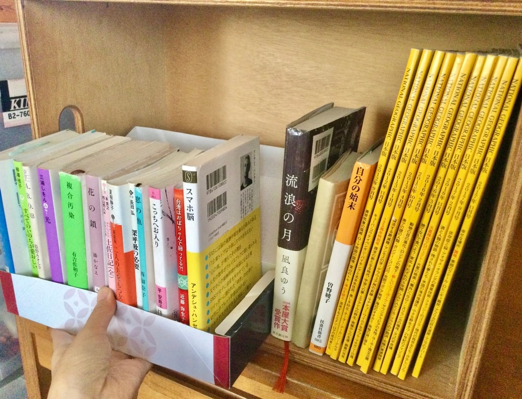 お菓子の箱を本棚の仕切りにして、本が横に倒れてしまうのを防ぐ
