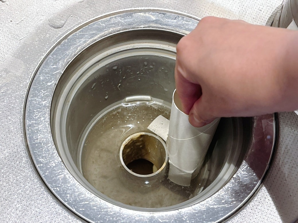 手順2.排水口にトイレットペーパーの芯を差し込んで、ゆっくり回しながら汚れをこすり落とす