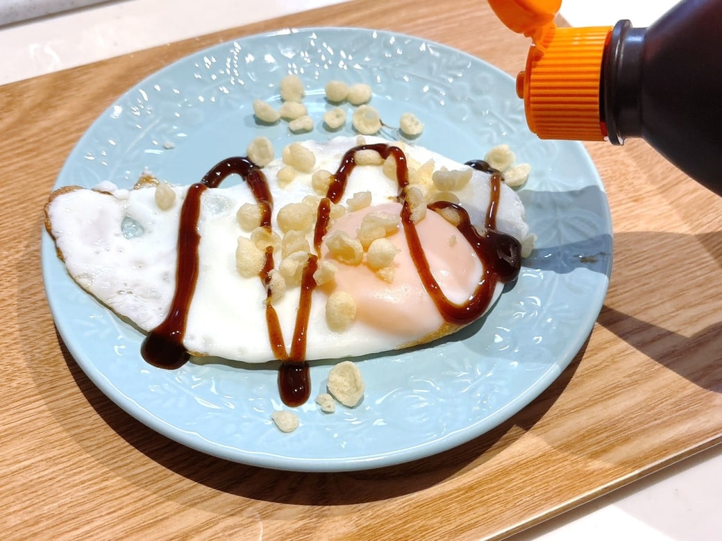 手順2.できあがった目玉焼きを皿に移し、天かす・お好みソースをかけて、青のりをふる