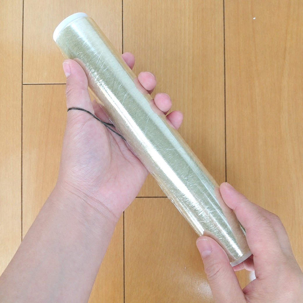 輪ゴムを広げた手でラップをさする人