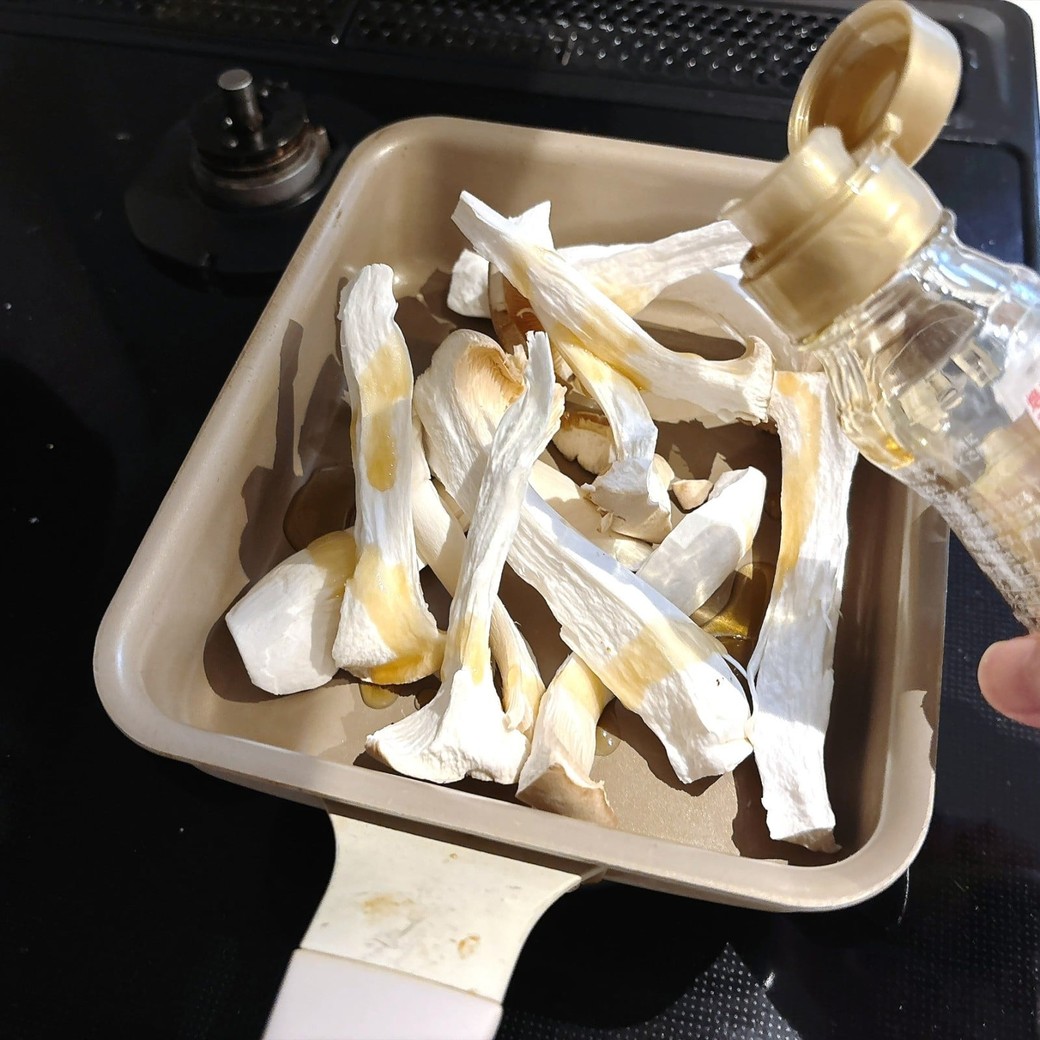 手順2．フライパンに入れたエリンギにごま油を回しかけ、こんがりするまで炒める