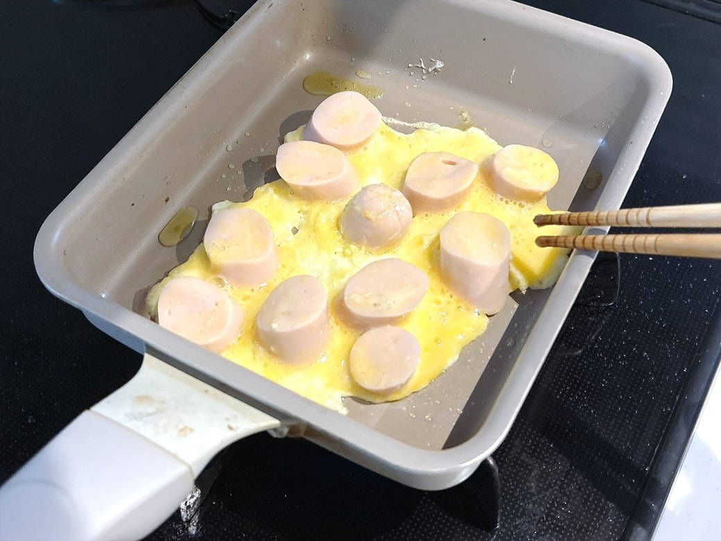 手順3．フライパンにオリーブオイルをひき、卵液をまとわせた魚肉ソーセージを焼く