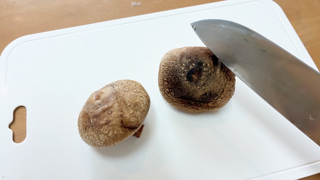 しいたけをスライスしようと包丁を握っている様子